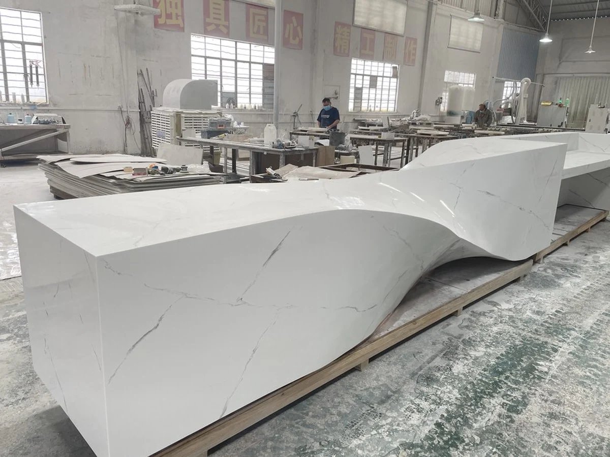 Sculpted white solid surface reception counter in the workshop
