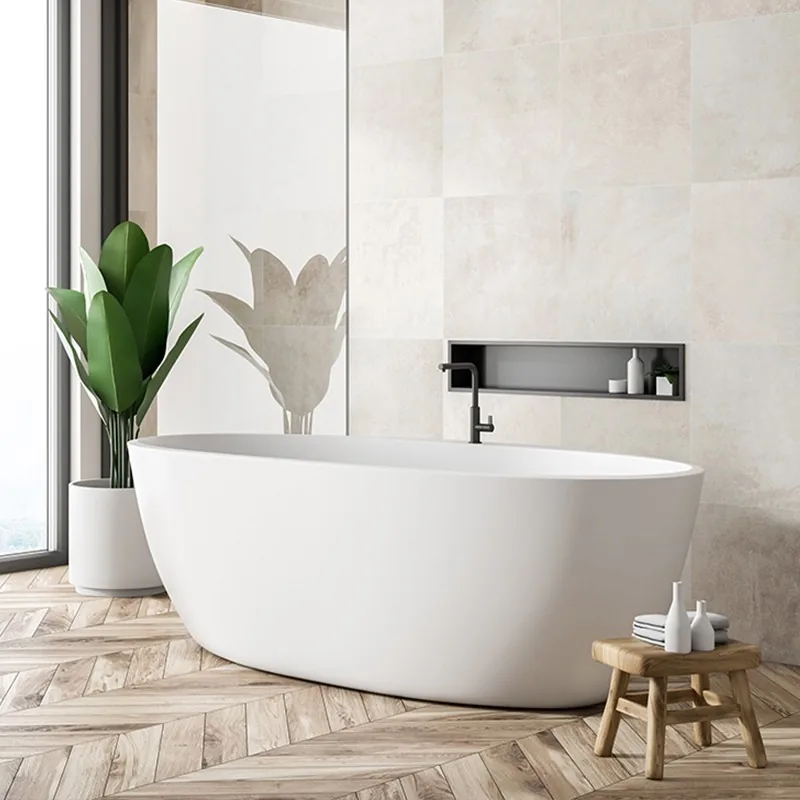 Freestanding white bathtub in a warm, stone-toned bathroom