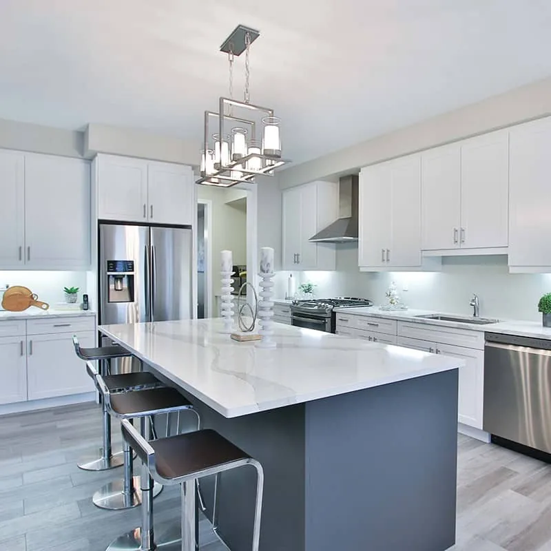 Light-filled kitchen with a white solid surface island and blue cabinetry