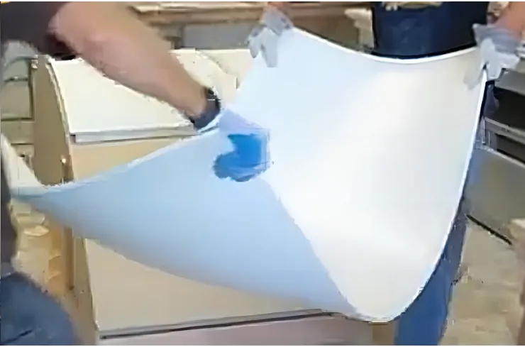 A fabricator holding a curved, heat-formed solid surface sheet