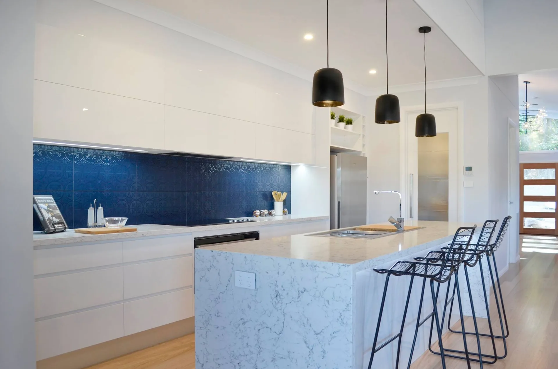 Architectural kitchen with a continuous solid surface island, integrated worktop and pendant lighting